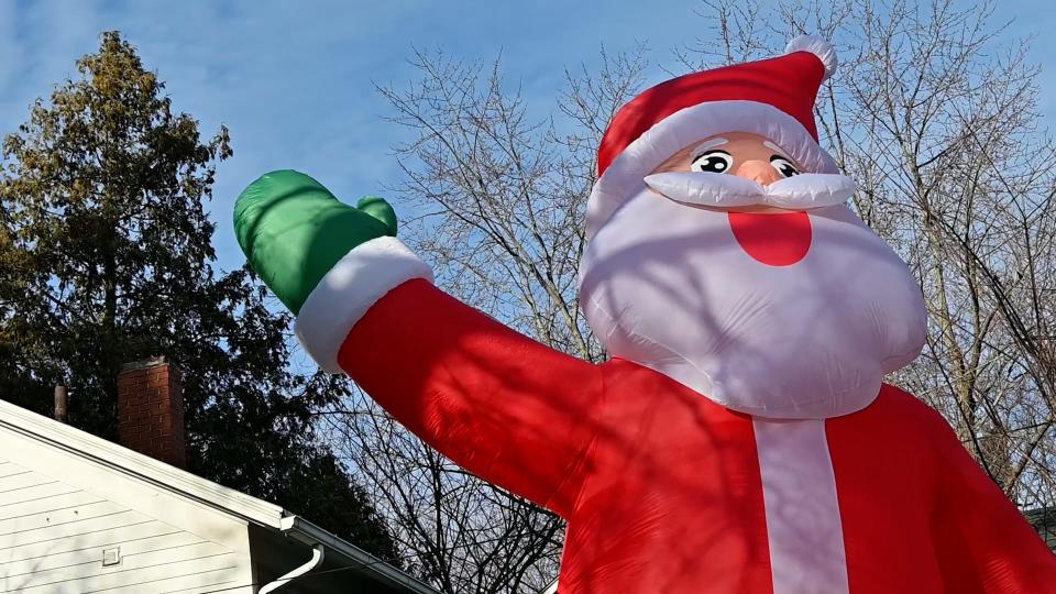 A Santa blowup stands outside a home