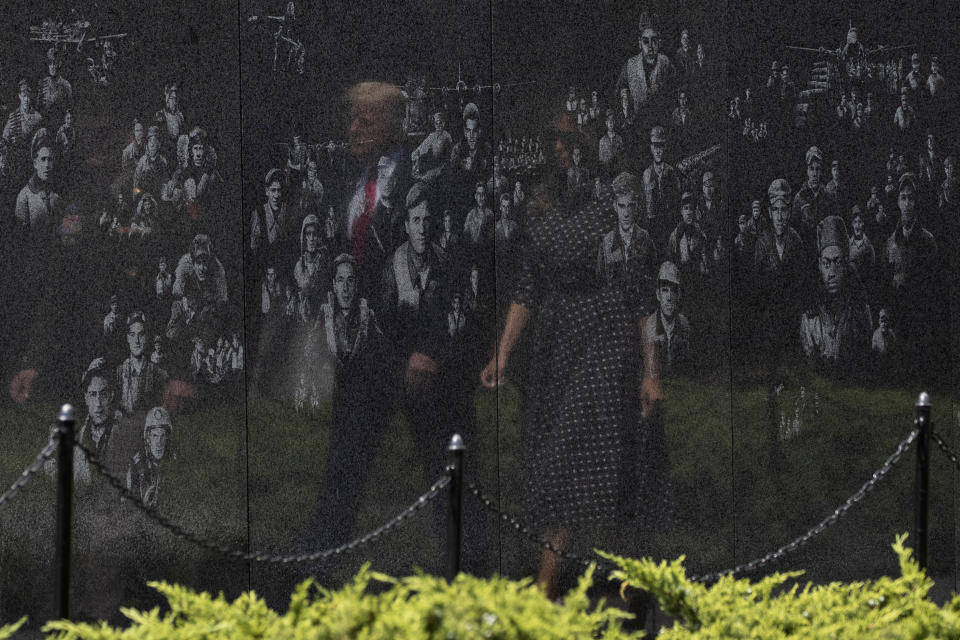 FILE - In this June 25, 2020, file photo reflected in a memorial, President Donald Trump, accompanied by first lady Melania Trump, arrives at the Korean War Veterans Memorial for a wreath placing ceremony in Washington. The relationship between the nation's military community and the Republican president has been strained repeatedly over the course of Trump's turbulent first term. (AP Photo/Alex Brandon, File)