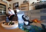 Celine Cornet sits in her apartment next to part of her collection of 2,200 pieces of panda collectables in Haccourt March 11, 2014. REUTERS/Yves Herman