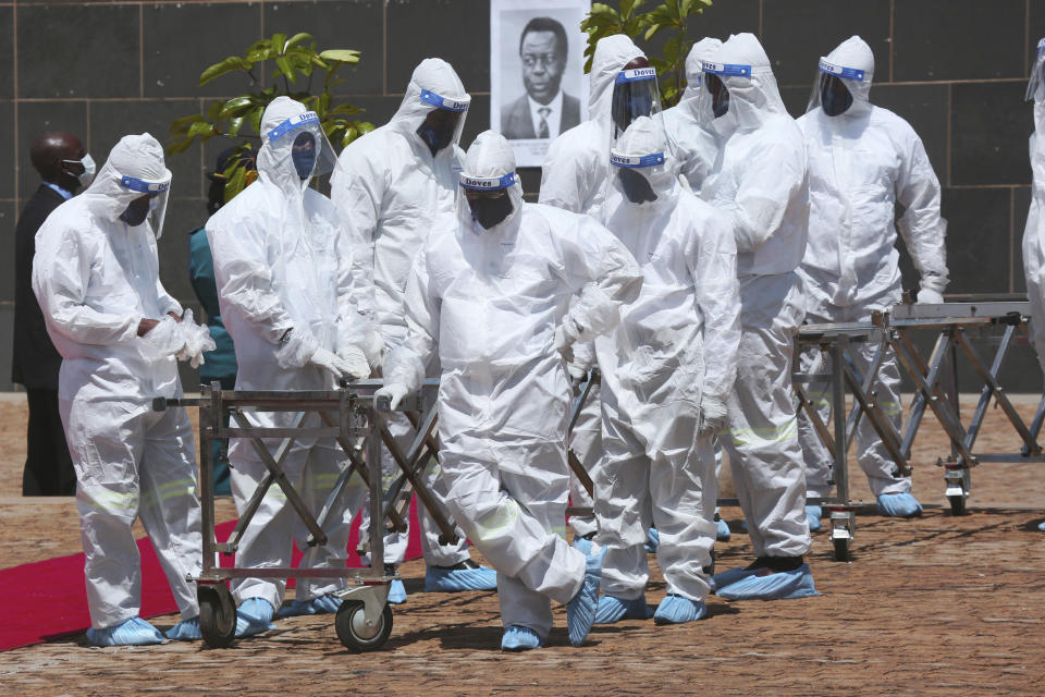 FILE - Pallbearers wait for coffins to arrive at a state burial of government ministers who died of COVID-19 in Harare, Zimbabwe, on Jan. 21, 2021. The World Health Organization said Friday May 5, 2023 that COVID-19 no longer qualifies as a global emergency, marking a symbolic end to the devastating coronavirus pandemic that triggered once-unthinkable lockdowns, upended economies and killed millions of people worldwide. (AP Photo/Tsvangirayi Mukwazhi, File)