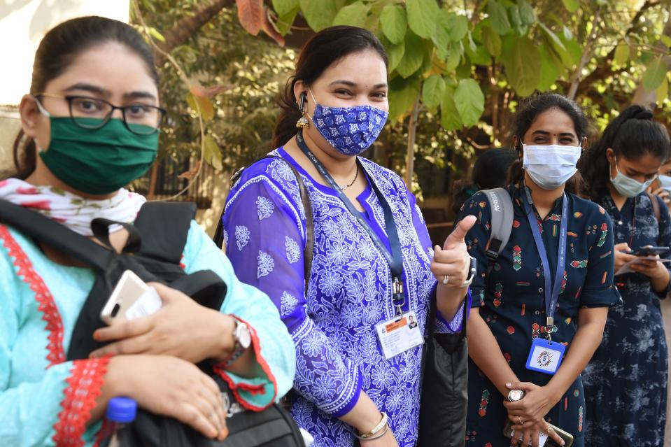 A health worker gives a thumbs-up gesture as she waits in line to receive a dose of a Covid-19 coronavirus vaccine at the Cooper hospital in Mumbai on January 16, 2021. (Photo by Punit PARANJPE / AFP) (Photo by PUNIT PARANJPE/AFP via Getty Images)