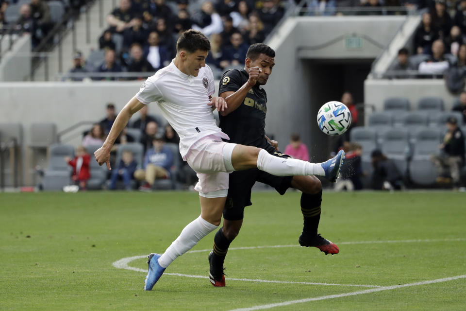 Inter Miami CF's Robbie Robinson, left, shoots as Los Angeles FC's Eddie Segura defends during the first half of an MLS soccer match Sunday, March 1, 2020, in Los Angeles. (AP Photo/Marcio Jose Sanchez)