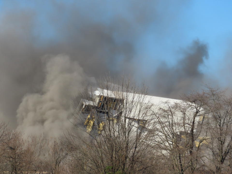 Smoke and dust rise from the site of a former coal-fired power plant in Logan Township, N.J., after it collapsed when explosives were detonated to implode it on Friday, Dec. 2, 2022. The plant was razed to make way for a battery facility to store energy from clean sources such as wind and solar. (AP Photo/Wayne Parry)