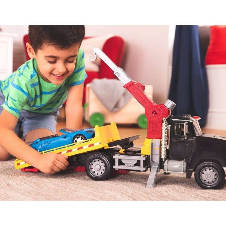 Kid playing with crane truck and car