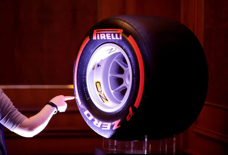 FILE PHOTO: A woman touches a Pirelli tyre displayed for a news conference by ChemChina and Pirelli in Beijing