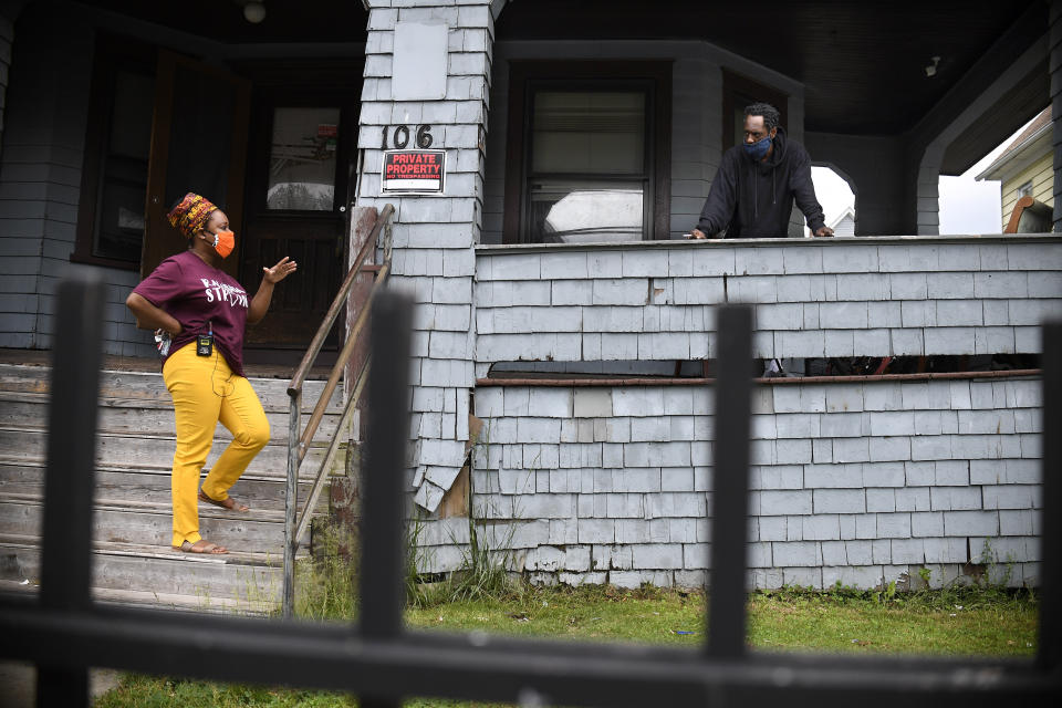 In this Friday, June 5, 2020 photo, Sarah J. Rawson Elementary School Principal Dr. Tayarisha Batchelor, left, talks with a parent about distant learning during a visit to a home in Hartford, Conn. (AP Photo/Jessica Hill)