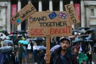 A demonstrator holds up a placard saying "Stand together, Stop Brexit" at an anti-Brexit protest in Trafalgar Square on June 28, 2016