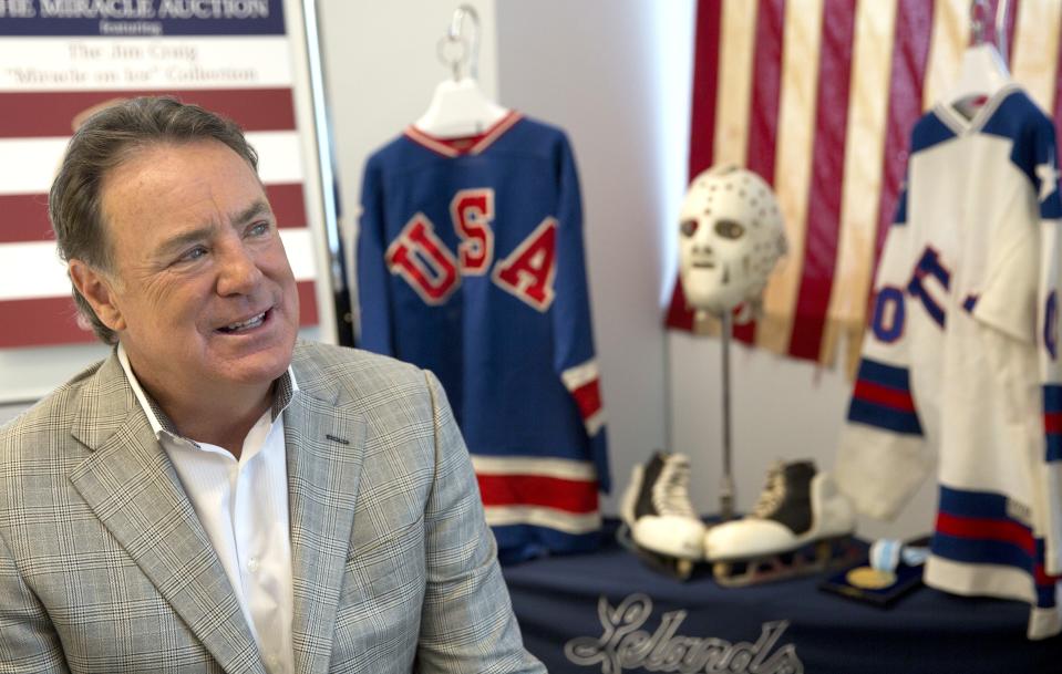 Jim Craig, the hockey goaltender who helped the U.S. win a gold medal at the 1980 Winter Olympics, is framed by a display featuring the jerseys, skates and goaltending equipment he wore in the Soviet and Finland games as well as the iconic American flag that was draped over his shoulders after the gold medal win, as he poses for a photo, on May 24, 2016, in New York. Craig also played 13 games during the 1981-82 season for the minor league Erie Blades, which, at the time, was an AHL affiliate for the Boston Bruins. Craig played 30 games for three NHL teams in the early 1980s.