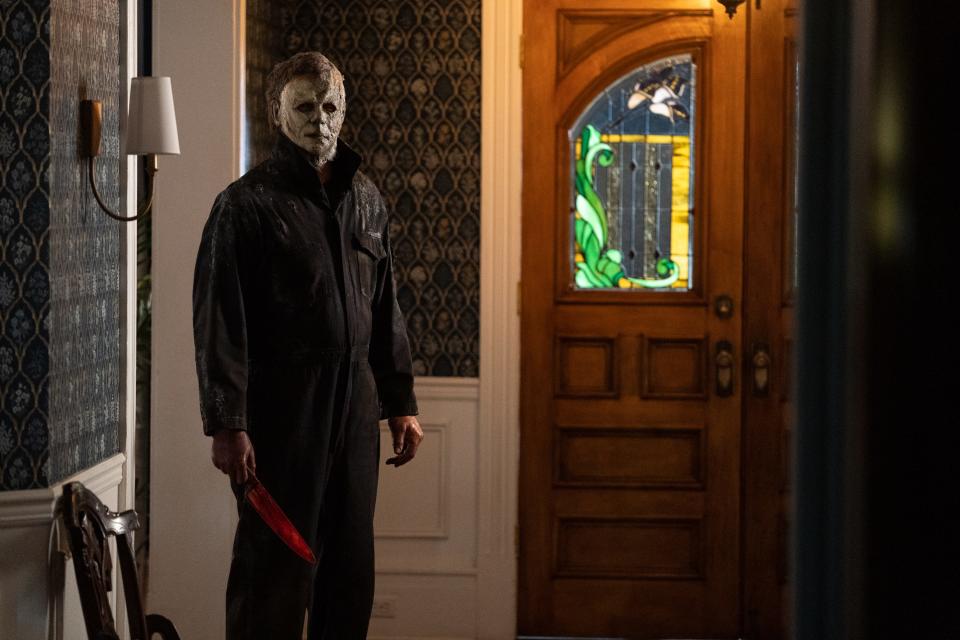 Michael Myers standing in the entrance of a home with a knife in "Halloween Ends."