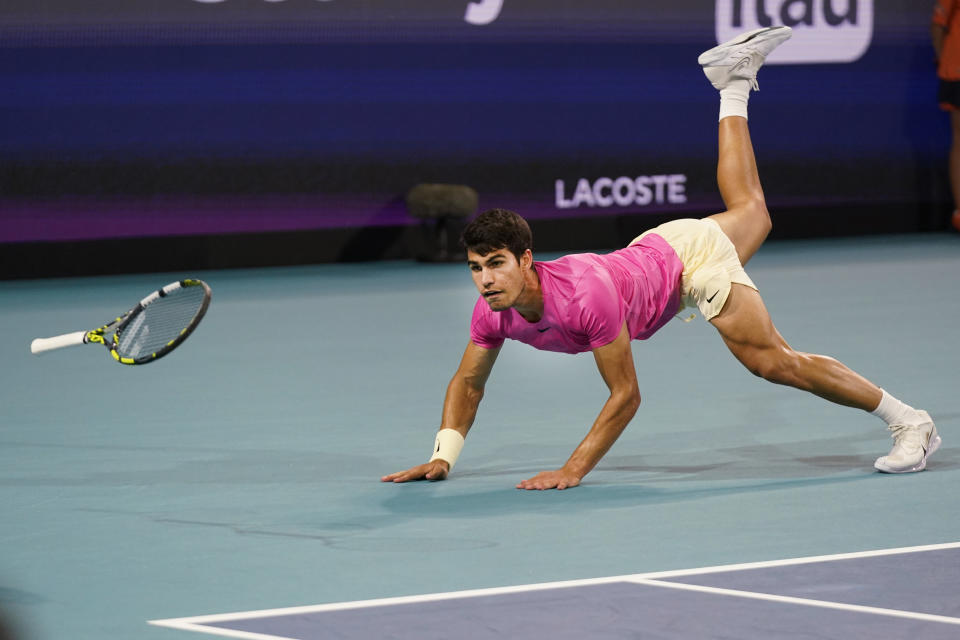 Carlos Alcaraz, of Spain, dives as he attempts to return a shot by Jannik Sinner, of Italy, during the Miami Open tennis tournament, Friday, March 31, 2023, in Miami Gardens, Fla. (AP Photo/Wilfredo Lee)