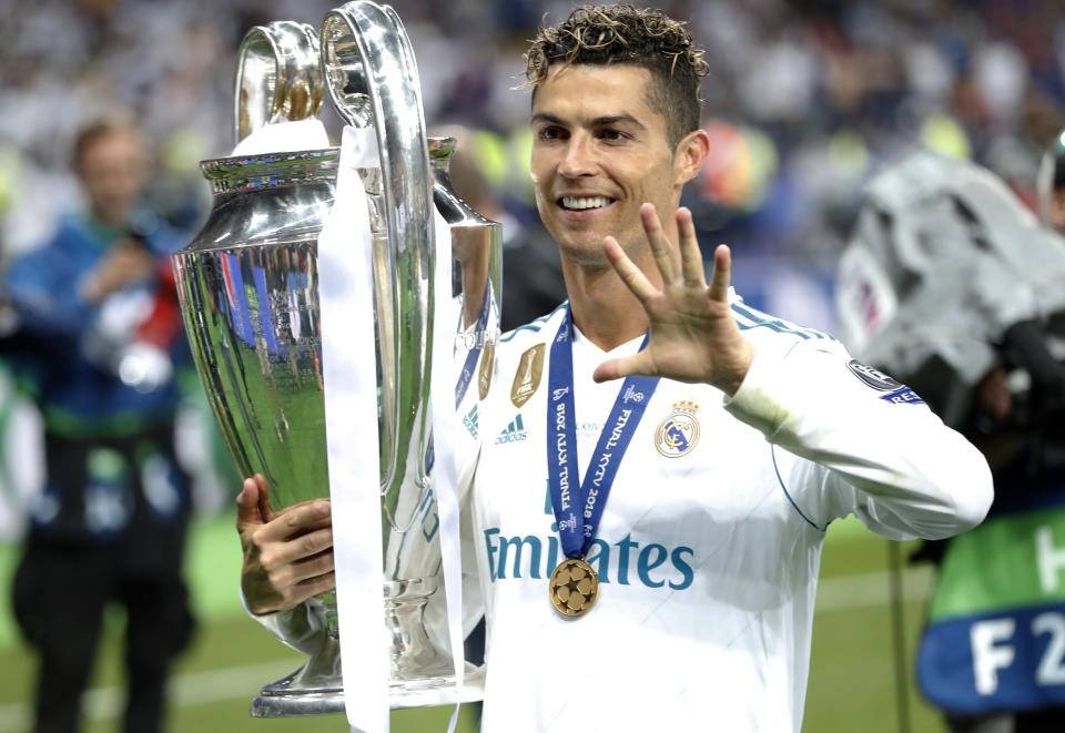 FILE - In this Saturday, May 26, 2018 file photo Real Madrid's Cristiano Ronaldo celebrates with the trophy after winning the Champions League Final soccer match between Real Madrid and Liverpool at the Olimpiyskiy Stadium in Kiev, Ukraine. Neither Lionel Messi nor Cristiano Ronaldo will be in the Champions League quarterfinals for the first time since 2005. The two greatest players of the current generation were both eliminated from the competition this week. Messi scored a goal but missed a penalty as Barcelona was eliminated by Paris Saint-Germain. Ronaldo and his Juventus teammates were ousted by Porto the night before. Ronaldo has won five Champions League titles in his career. Messi has won four. (AP Photo/Pavel Golovkin, File)