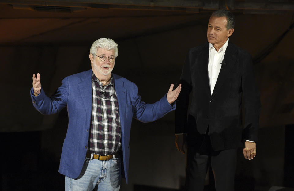 "Star Wars" film franchise creator George Lucas, left, addresses the crowd as Walt Disney Co. Chairman and CEO Bob Iger looks on during a dedication ceremony for the Star Wars: Galaxy's Edge attraction at Disneyland Park, Wednesday, May 29, 2019, in Anaheim, Calif. (Photo by Chris Pizzello/Invision/AP)