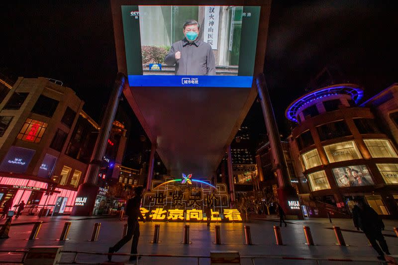 A screen shows a CCTV state media broadcast of Chinese President Xi Jinping's visit to Wuhan at a shopping centre in Beijing as the country is hit by the outbreak of the novel coronavirus
