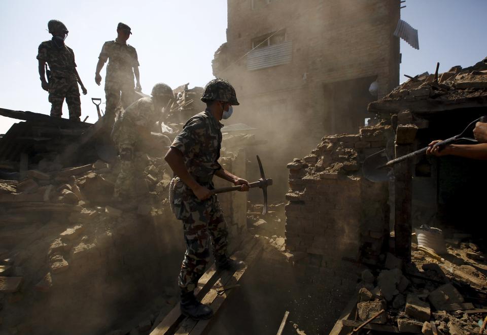 Nepalese army personnel search for victims trapped inside collapsed buildings following Saturday's earthquake in Bhaktapur, Nepal