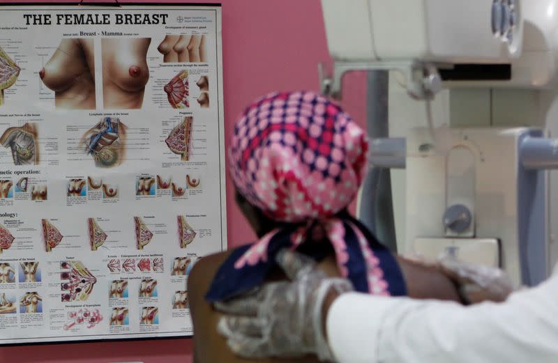 A patient looks at a chart as she prepares to undergo a mammogram X-ray picture of the breast to look for early signs of breast cancer in the radiology unit at the Kenyatta National Hospital in Nairobi