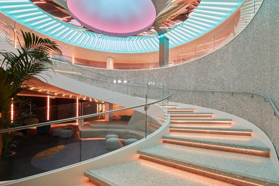 A spiral stairway is outfitted with elegantly hidden lights.