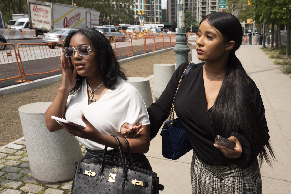 Azriel Clary, left, and Joycelyn Savage, two women who lived in Chicago with R&B singer R. Kelly, leave Brooklyn federal court following his arraignment, Friday, Aug. 2, 2019 in New York. Kelly faces charges he sexually abused women and girls. (AP Photo/Mark Lennihan)