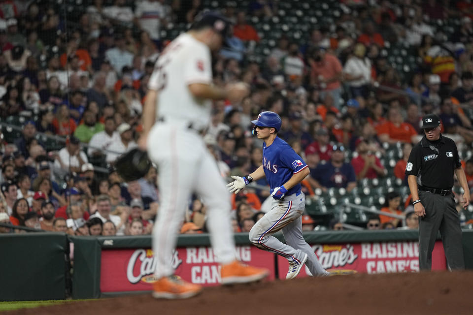 Texas Rangers' Corey Seager, right, runs the bases after hitting a two-run home run off Houston Astros starting pitcher Jose Urquidy, left, during the third inning of a baseball game Tuesday, Aug. 9, 2022, in Houston. (AP Photo/David J. Phillip)