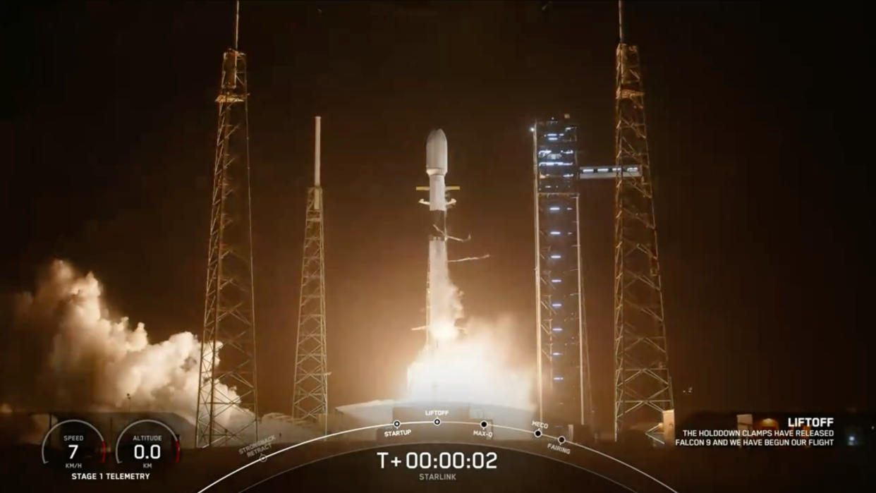  A black-and-white spacex falcon 9 rocket launches into a night sky. 