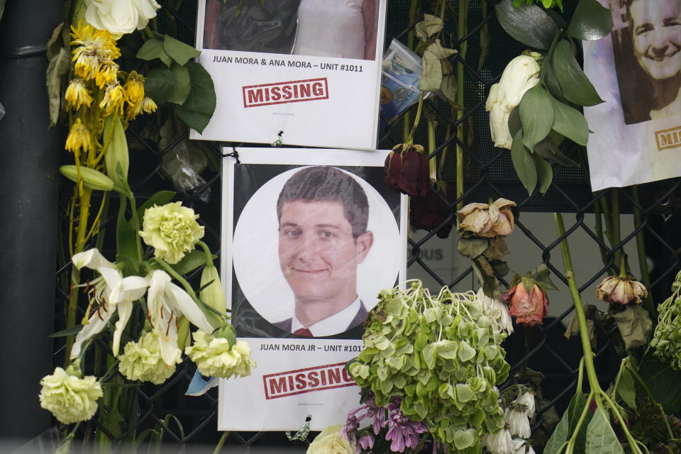 This June 29, 2021, photo shows a memorial wall for the victims of the Champlain Towers South building collapse in Surfside, Fla., with a photo of Juan Mora Jr. (AP Photo/Gerald Herbert)