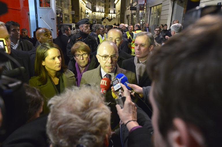 French Interior Minister Bernard Cazeneuve (C) speaks to journalists at the scene where a driver ploughed into a Christmas market in Nantes on December 22, 2014