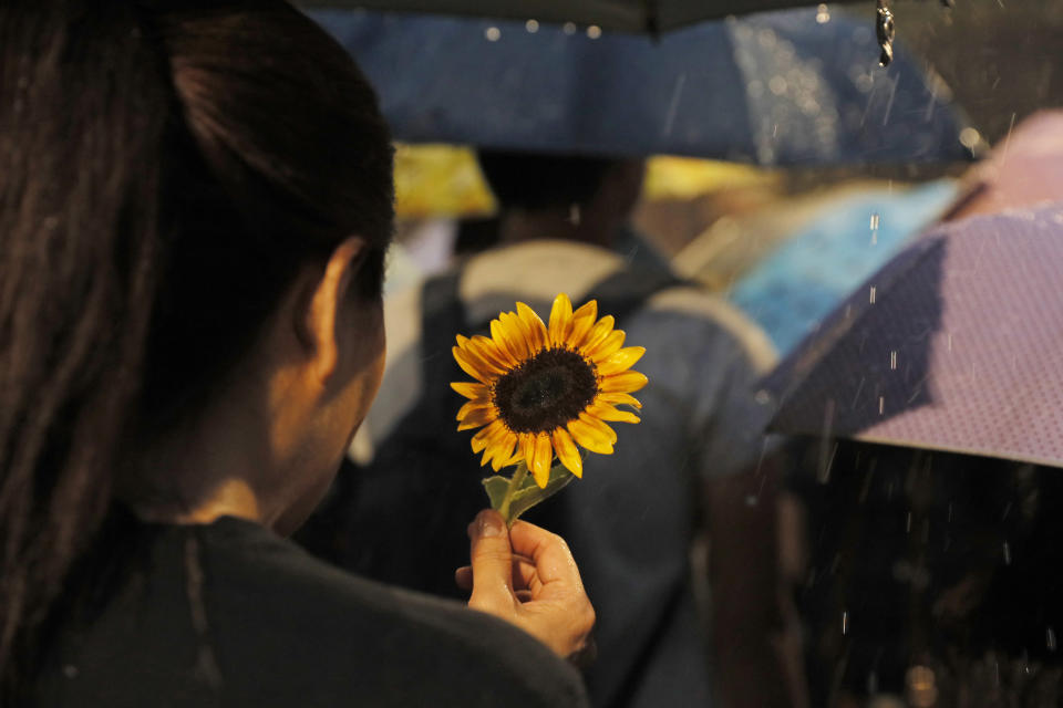 Attendees take part in a public memorial for Marco Leung, the 35-year-old man who fell to his death weeks ago after hanging a protest banner against an extradition bill, in Hong Kong, Thursday, July 11, 2019. The parents of Leung urged young people to stay alive to continue their struggle. (AP Photo/Kin Cheung)