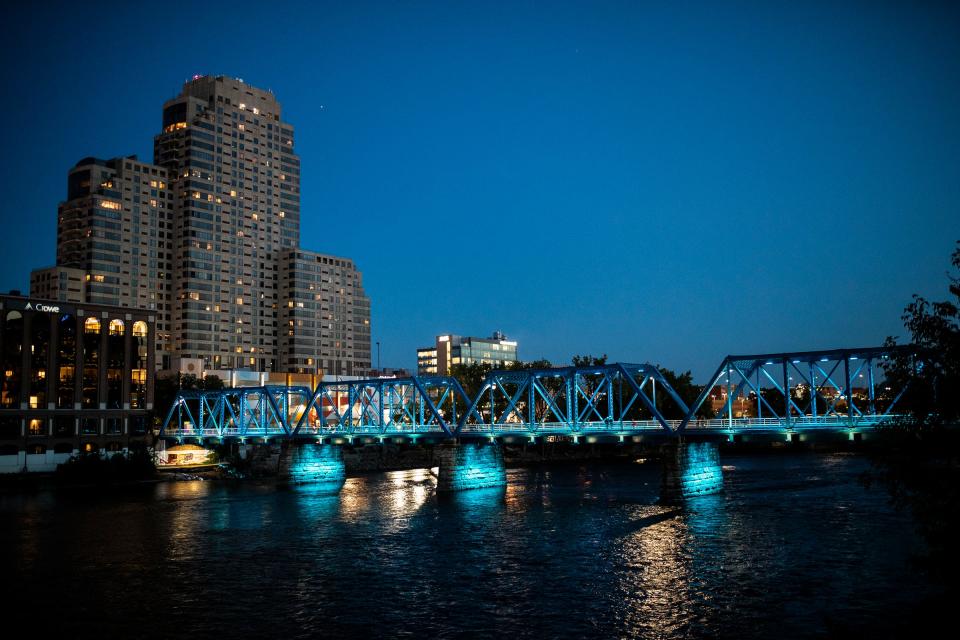 Pedestrians cross the illuminated Blue Bridge in downtown Grand Rapids, Mich., during ArtPrize on Wednesday.