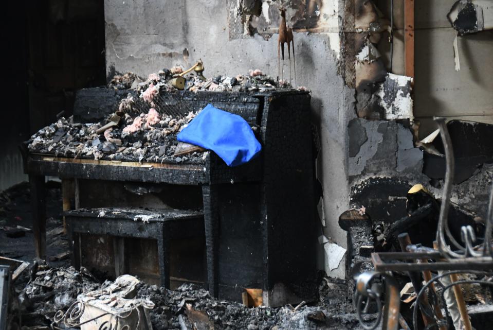 A piano that has been in the Lott family for more than 100 years sits amid blackened debris inside their Melbourne Beach home.