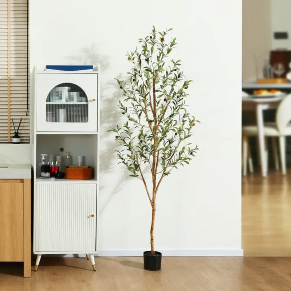 Faux potted plant next to a white cabinet in a modern room setting