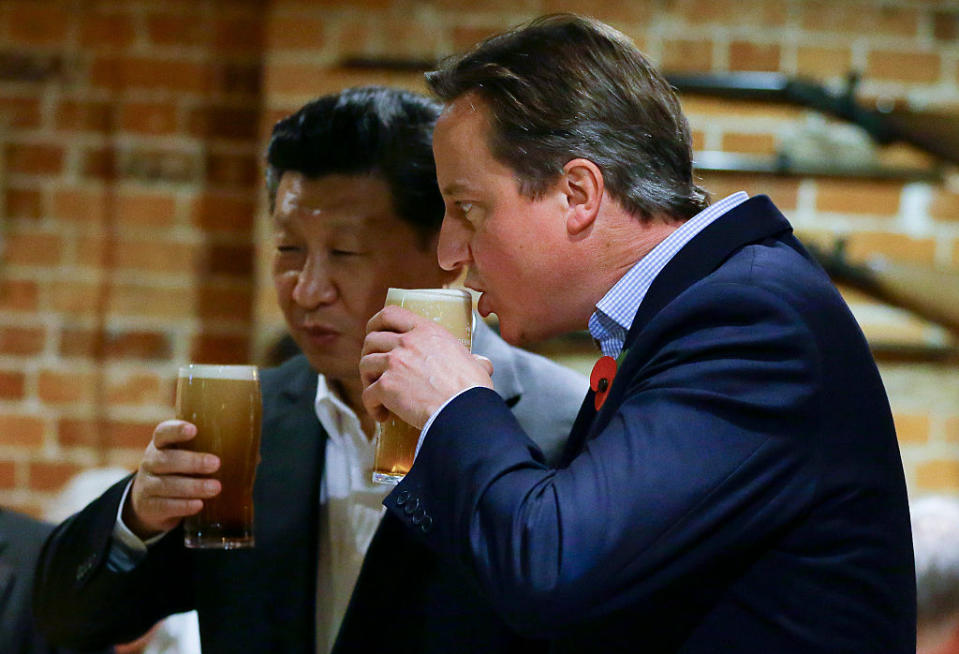 PRINCES RISBOROUGH, ENGLAND - OCTOBER 22: China's President Xi Jinping and Britain's Prime Minister David Cameron drink a pint of beer during a visit to the The Plough pub on October 22, 2015 in Princes Risborough, England. The President of the People's Republic of China, Mr Xi Jinping and his wife, Madame Peng Liyuan, are paying a State Visit to the United Kingdom as guests of The Queen.  They will stay at Buckingham Palace and undertake engagements in London and Manchester. The last state visit paid by a Chinese President to the UK was Hu Jintao in 2005.  (Photo by Kirsty Wigglesworth - WPA Pool/Getty Images)