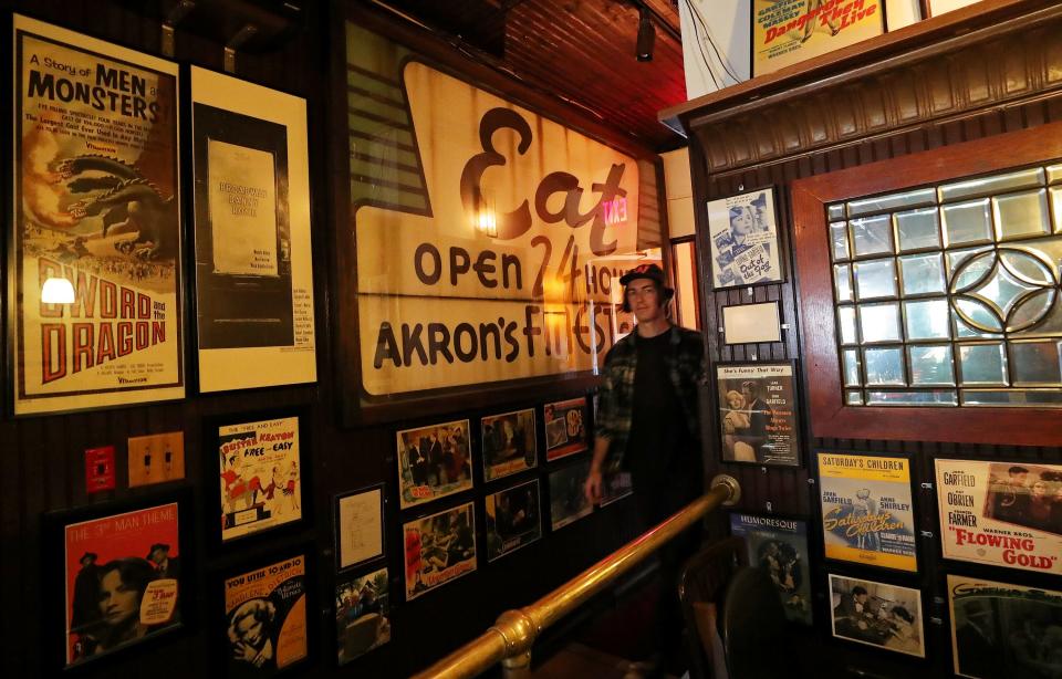 Customers pass by the large porcelain sign that reads "Eat. Open 24 Hours. Akron's Finest Grill" as they enter Larry's Main Entrance.