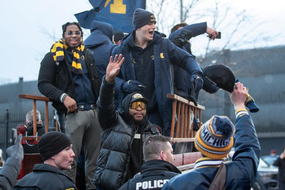 Michigan defensive lineman Kris Jenkins, quarterback J.J. McCarthy and linebacker Michael Barrett wave at fans during the National Championship parade in Ann Arbor on Saturday, Jan. 13, 2024.