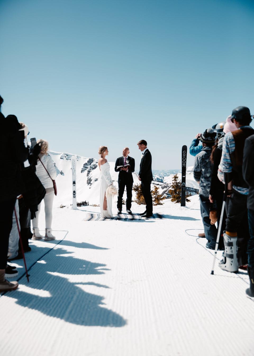 A bride and groom say their vows on a snowy mountaintop.