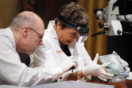 Executive Director of the Massachusetts Archives, Michael Comeau, and MFA conservator Pam Hatchfield open a time capsule, which was placed under a cornerstone of the State House in 1795, at the Museum of Fine Arts, Boston, Massachusetts, January 6, 2015. REUTERS/Brian Snyder