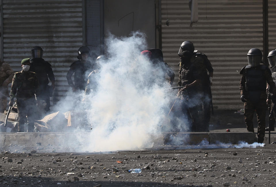 Iraqi security forces fire tear gas, a slingshot and smoke bombs during clashes between Iraqi security forces and anti-government protesters, in Baghdad, Iraq, Monday, Nov. 11, 2019. (AP Photo/Hadi Mizban)