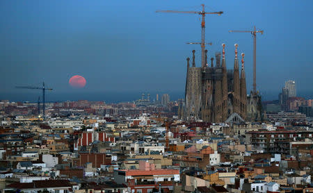 FILE PHOTO: A full moon "Super Blue Blood Moon" rises behind Mediterranean sea, next to Sagrada Familia Basilica in Barcelona, Spain January 31, 2018. REUTERS/Albert Gea/File Photo