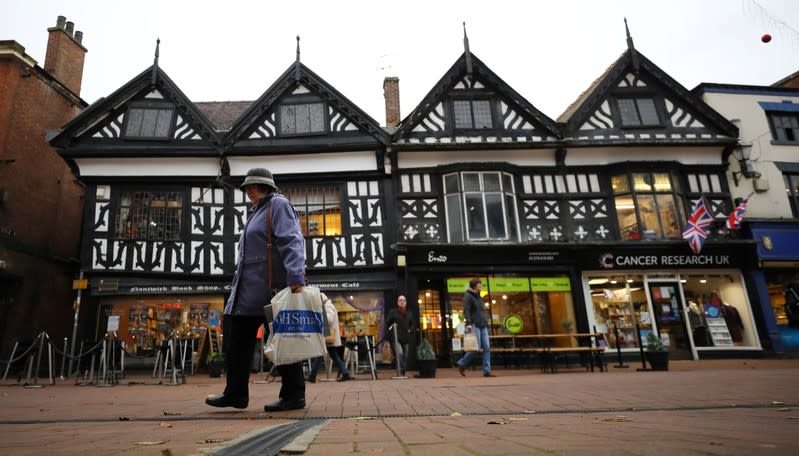 Woman walks past a row of shops in the town centre of Nantwich