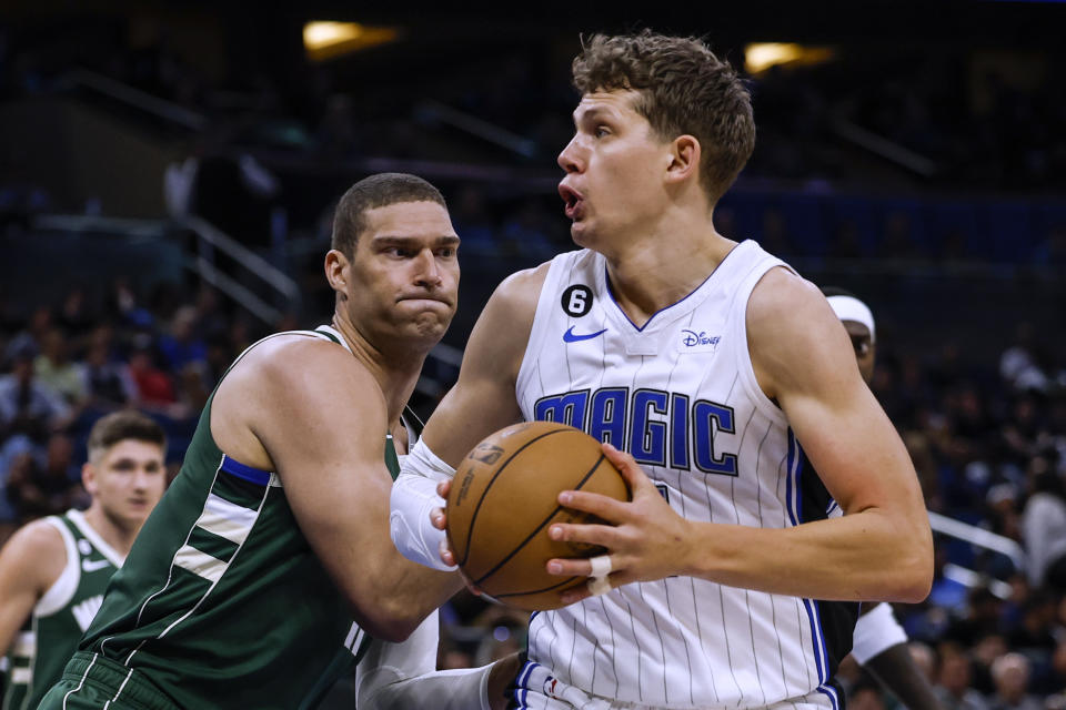 Milwaukee Bucks center Brook Lopez, front left, defends Orlando Magic center Moritz Wagner during the first half of an NBA basketball game Tuesday, March 7, 2023, in Orlando, Fla. (AP Photo/Kevin Kolczynski)