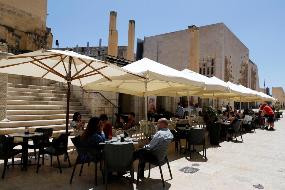 People sit at an outdoor restaurant in Valletta, Malta (REUTERS)