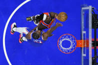 Oklahoma City Thunder's Luguentz Dort, top, goes up for a shot against Philadelphia 76ers' Joel Embiid during the first half of an NBA basketball game, Tuesday, April 2, 2024, in Philadelphia. (AP Photo/Matt Slocum)