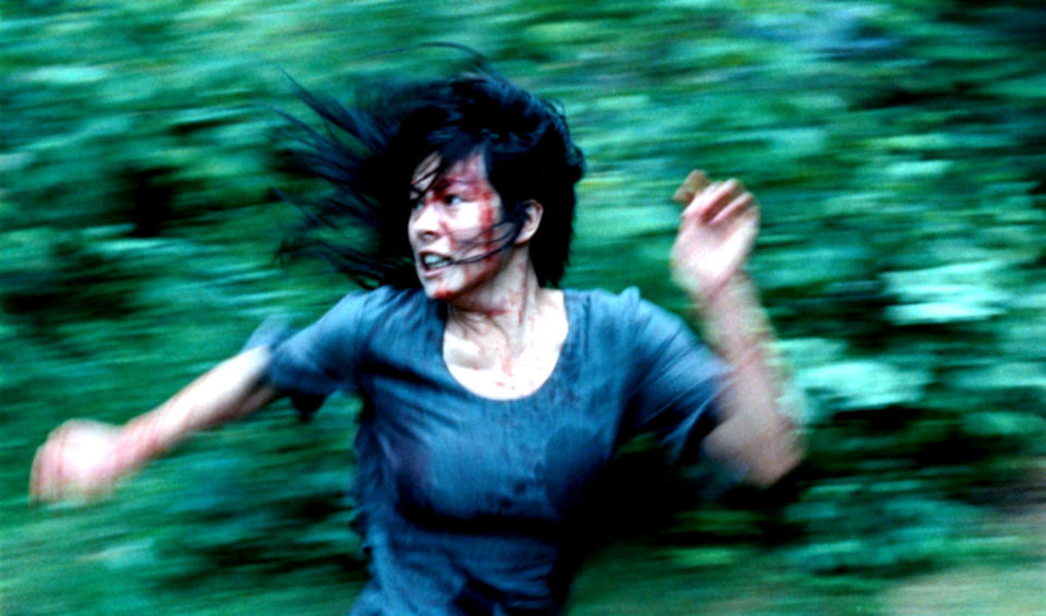 A woman with blood on her face running