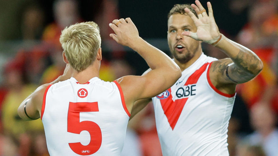 Buddy Franklin celebrates a goal with Sydney Swans teammate Isaac Heeney.