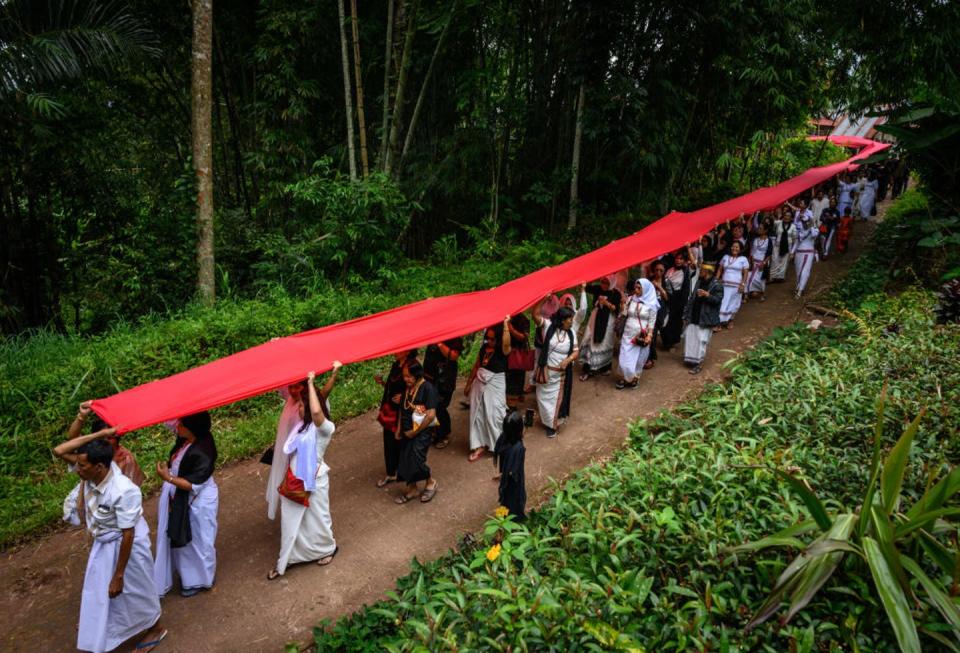 <span class="caption">Residents participate in a funeral procession to honor ancestors in Tana Toraja Regency, South Sulawesi, Indonesia.</span> <span class="attribution"><a class="link " href="https://www.gettyimages.com/detail/news-photo/residents-are-seen-pulling-red-cloth-during-the-rambu-solo-news-photo/1131722427?adppopup=true" rel="nofollow noopener" target="_blank" data-ylk="slk:Hariandi Hafid/SOPA Images/LightRocket via Getty Images;elm:context_link;itc:0;sec:content-canvas">Hariandi Hafid/SOPA Images/LightRocket via Getty Images</a></span>