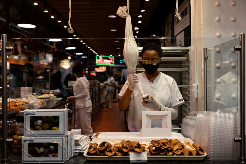 FOTO DE ARCHIVO: Trabajador rellena un cannoli en una panadería del Reading Terminal Market en Filadelfia, Pensilvania