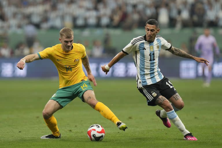 Ángel Di María intenta robarle la pelota a Riley McGree, durante el amistoso que Argentina y Australia juegan en Pekín