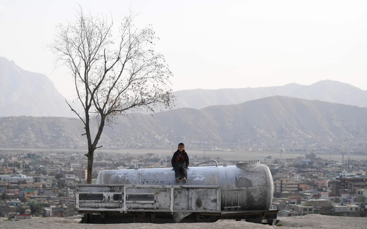 An Afghan child sits on a water tank at Nadir Khan hill in Kabul on October 1, 2019. (Photo by Sajjad HUSSAIN / AFP)SAJJAD HUSSAIN/AFP/Getty Images - AFP