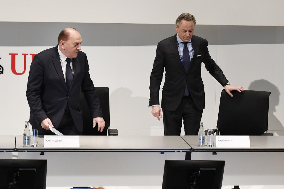 Axel A. Weber, left, Chairman of the Board of Directors of UBS and Ralph Hamers, right, new CEO of Swiss Bank UBS, take their seats for a press conference in Zurich, Switzerland, Thursday, Feb. 20, 2020. Dutchman Ralph Hamers will replace Sergio Ermotti, who is still UBS boss, on Nov. 1, 2020. (Walter Bieri/Keystone via AP)