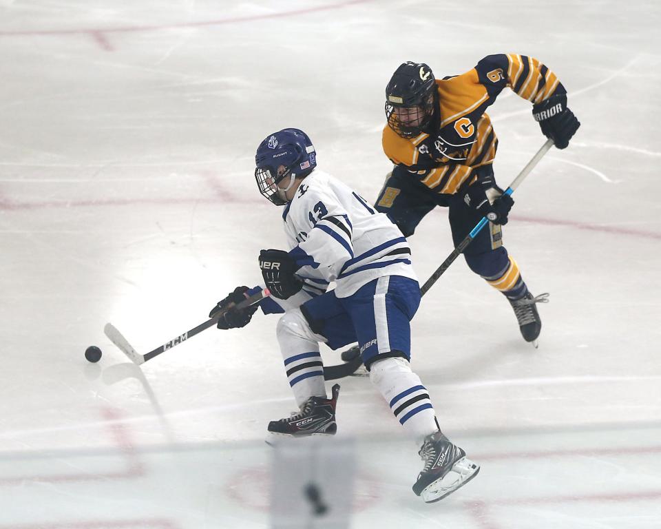 Scituate's Dan Brown looks to skate past Hanover’s Zach Lee during third period action of their game at Hobomock Ice Arena on Saturday, Dec. 18, 2021.