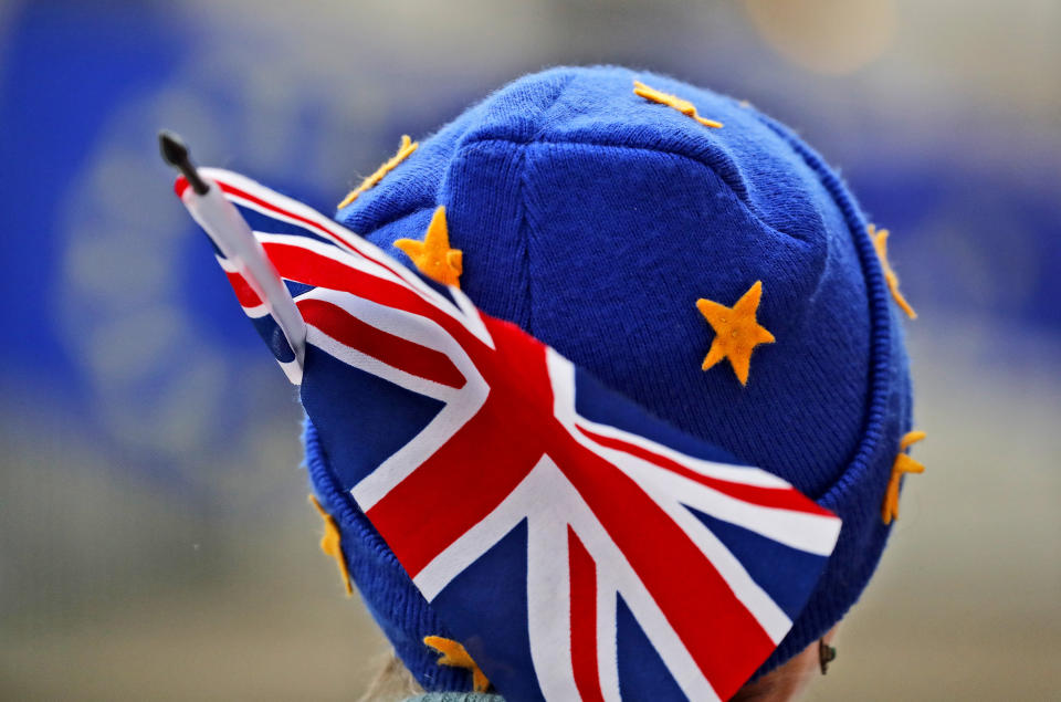 A protestor wears a European hat and a Union Jack flag opposite the Houses of Parliament. (AP Photo/Frank Augstein)