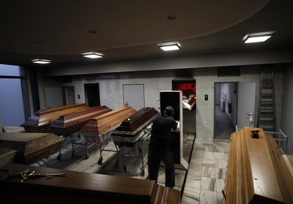 A worker moves a casket o be incinerated at a crematorium in Ostrava, Czech Republic, Thursday, Jan. 7, 2021. The biggest crematorium in the Czech Republic has been overwhelmed by mounting numbers of pandemic victims. With new confirmed COVID-19 infections around record highs, the situation looks set to worsen. Authorities in the northeastern city of Ostrava have been speeding up plans to build a fourth furnace but, in the meantime, have sought help from the government’s central crisis committee for pandemic coordination. (AP Photo/Petr David Josek)